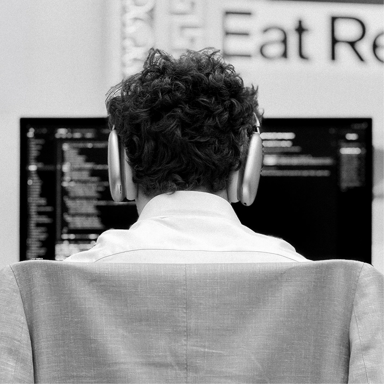 Engineer wearing headphones while working at a dual-monitor setup