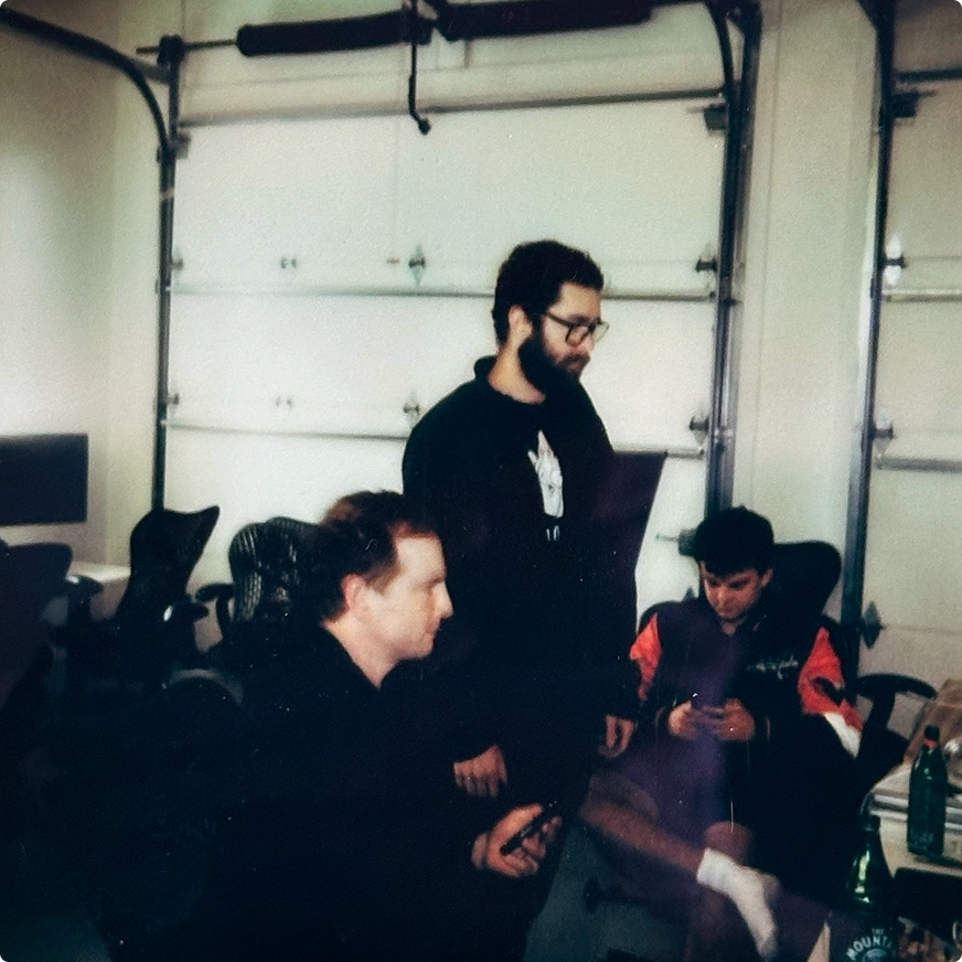 Three team members in a garage workspace