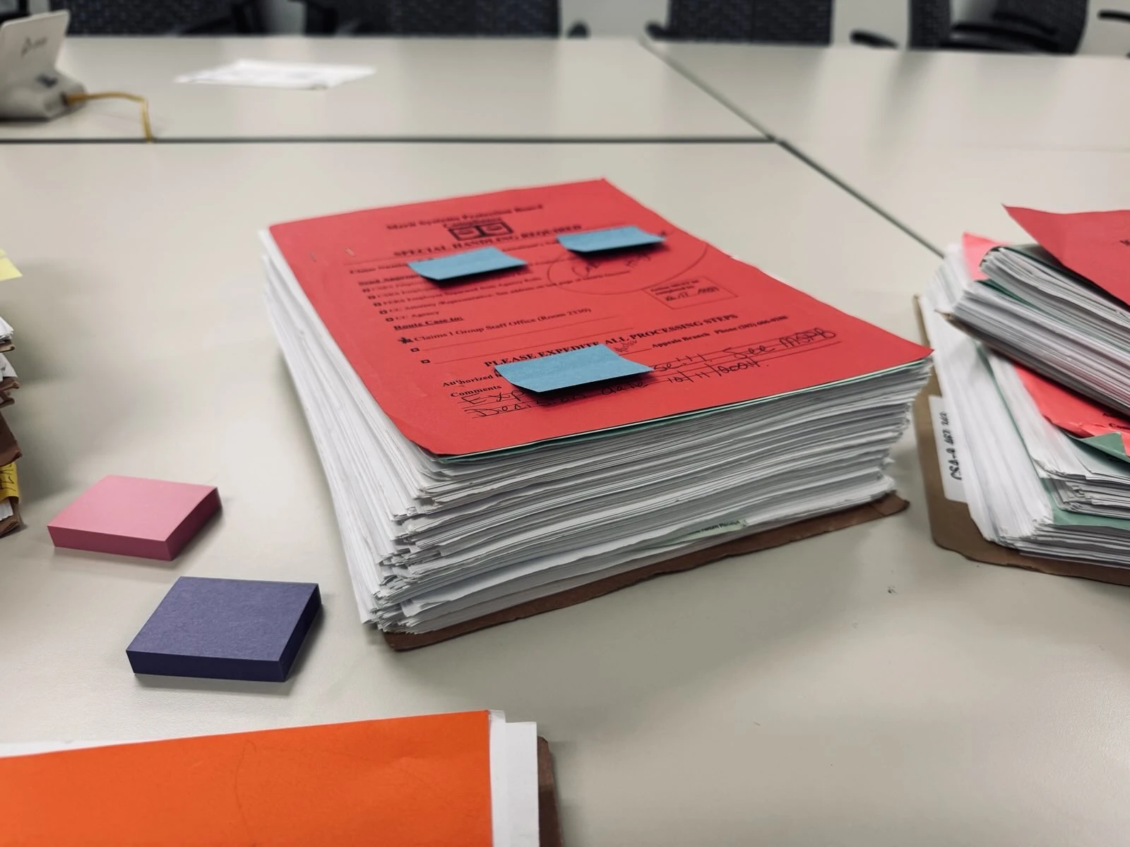 Stacks of paper retirement forms and case documents