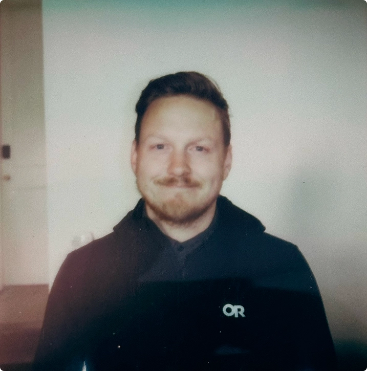 Bearded team member portrait in a black hoodie
