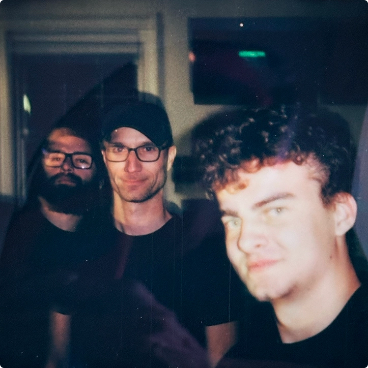 Three team members posing together at night